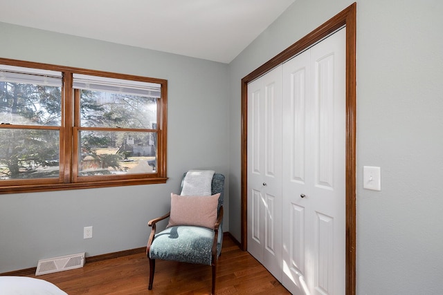 sitting room with baseboards, visible vents, and wood finished floors