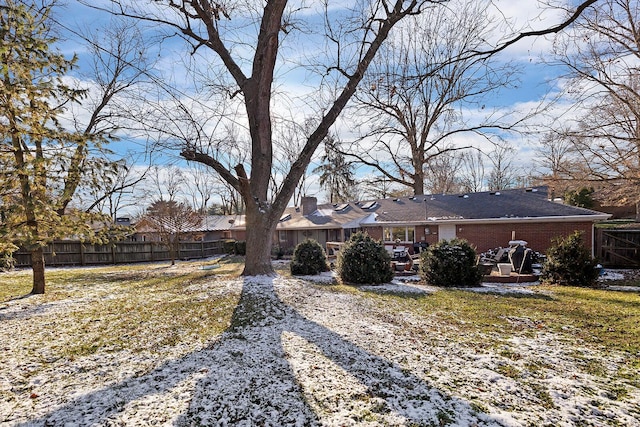 back of property with a yard, a chimney, fence, and brick siding