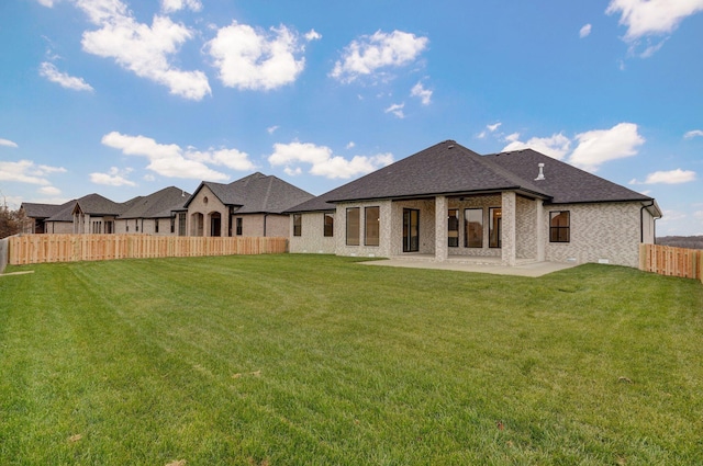 back of house with a patio and a lawn