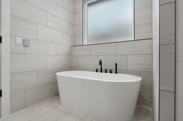 bathroom with tile walls and a bathtub