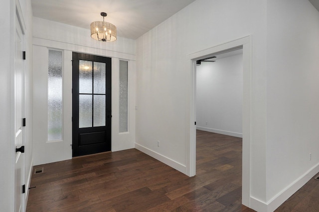 entryway with dark hardwood / wood-style flooring and a chandelier