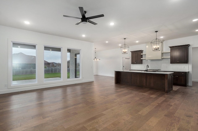 kitchen featuring sink, decorative light fixtures, ceiling fan, an island with sink, and dark brown cabinets