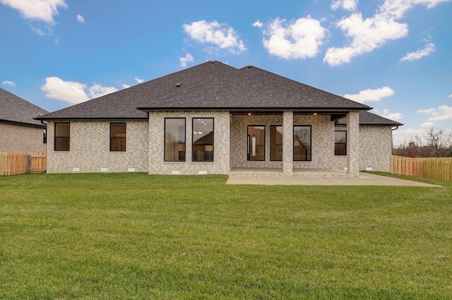 back of property with a lawn and a patio area