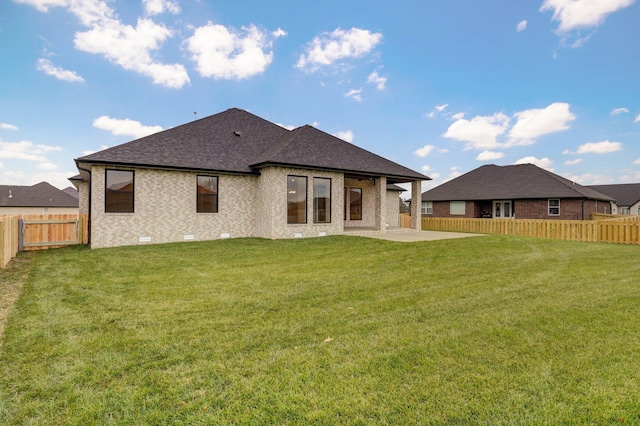 rear view of house featuring a lawn and a patio area