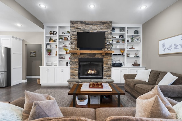 living room with a fireplace, built in shelves, and dark hardwood / wood-style floors