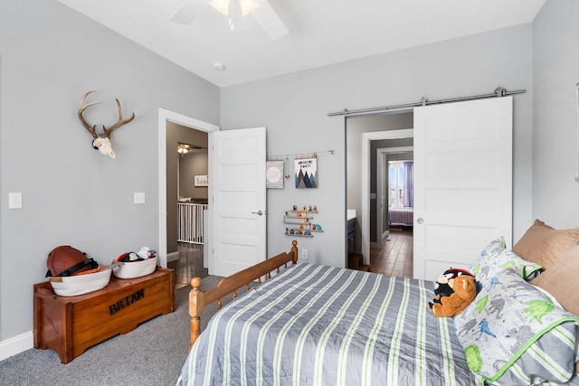 bedroom featuring ceiling fan, carpet flooring, and a barn door