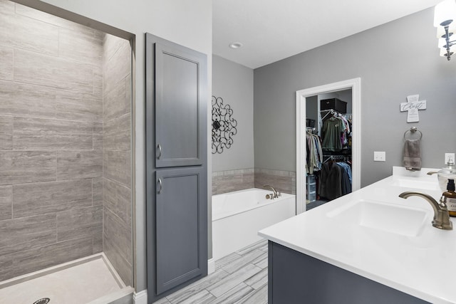 bathroom featuring separate shower and tub and vanity