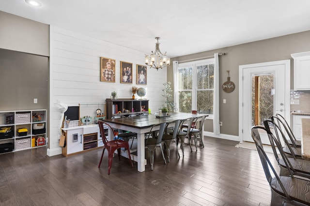 dining area with an inviting chandelier and dark hardwood / wood-style floors