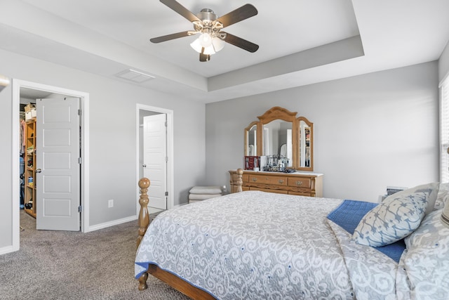 bedroom featuring ceiling fan, a raised ceiling, and carpet