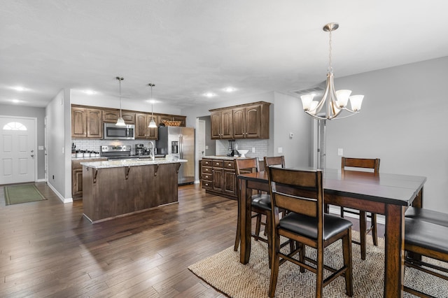 dining room with a notable chandelier, dark hardwood / wood-style flooring, and sink