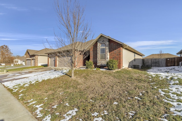 ranch-style house with a garage, cooling unit, and a lawn