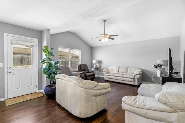 living room featuring lofted ceiling, dark wood-type flooring, a textured ceiling, and ceiling fan