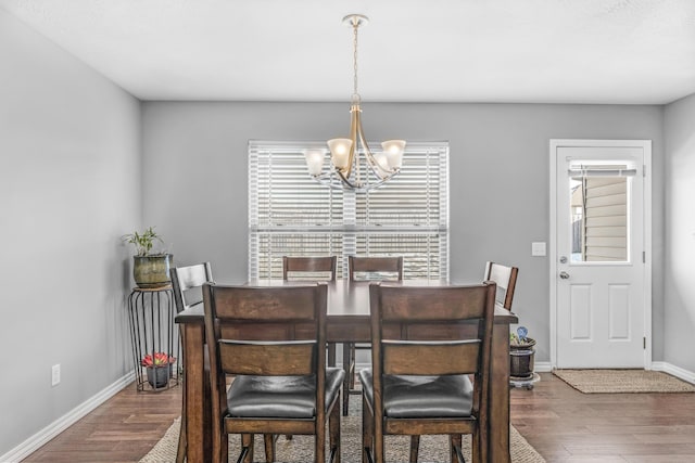 dining area with an inviting chandelier and dark wood-type flooring