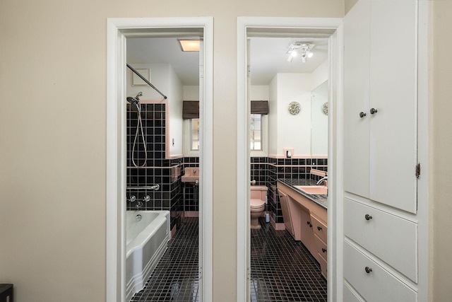 full bathroom featuring tile walls, vanity, tile patterned floors, and toilet