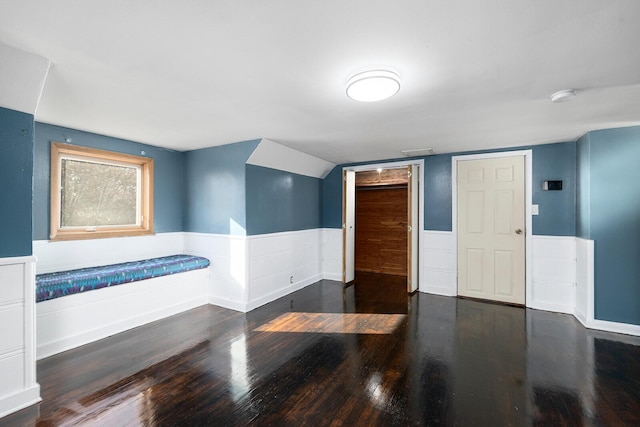 interior space featuring dark hardwood / wood-style flooring and vaulted ceiling