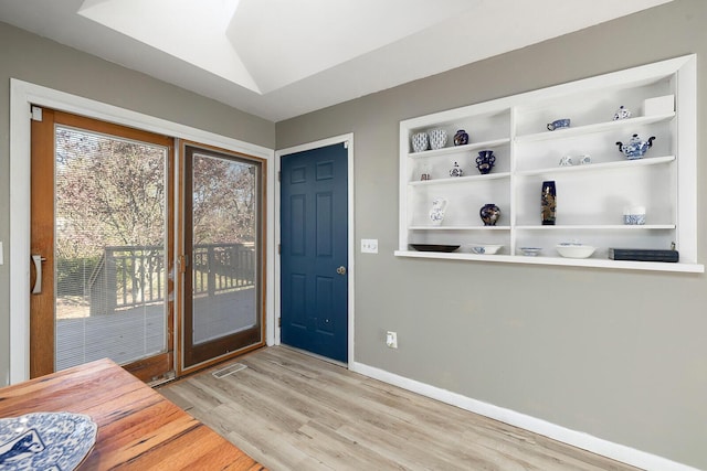 foyer entrance featuring vaulted ceiling and light hardwood / wood-style floors