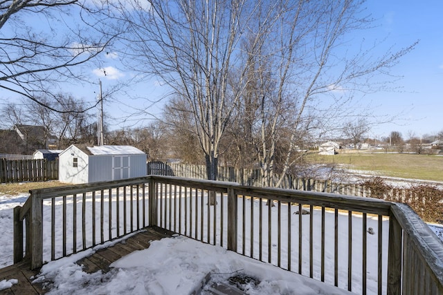 snow covered deck featuring a shed