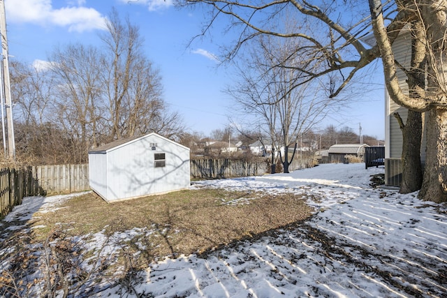 snowy yard with a storage shed