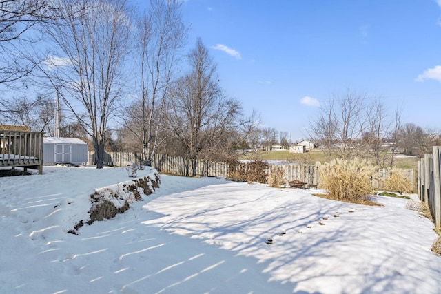 yard covered in snow with a storage unit