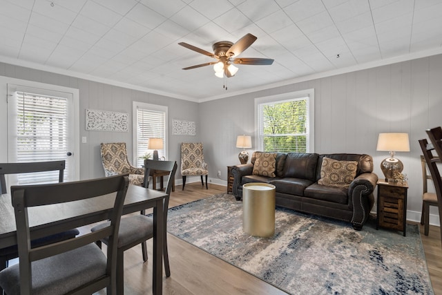 living room featuring hardwood / wood-style flooring, plenty of natural light, ornamental molding, and ceiling fan