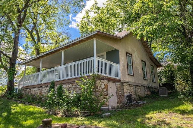 view of side of property with central air condition unit and a yard