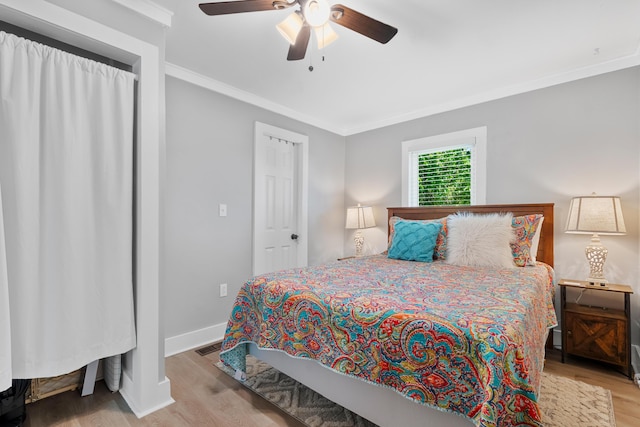 bedroom featuring light wood-type flooring, ceiling fan, and crown molding