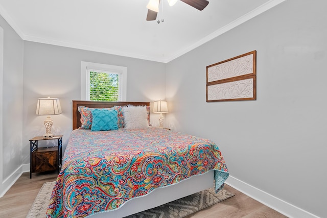 bedroom with light wood-type flooring, ceiling fan, and crown molding