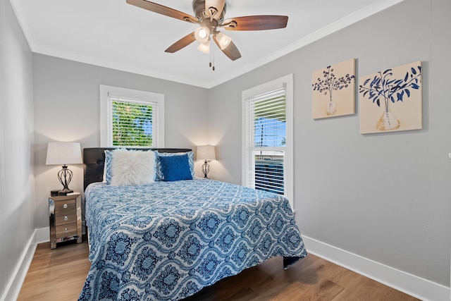 bedroom with ceiling fan, crown molding, and light wood-type flooring