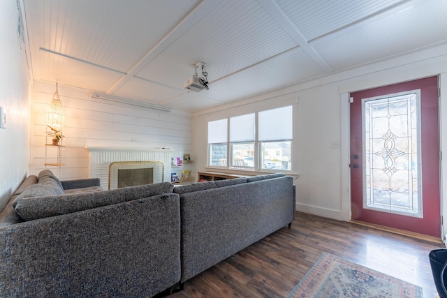 living room with a brick fireplace, dark hardwood / wood-style flooring, coffered ceiling, and wooden walls