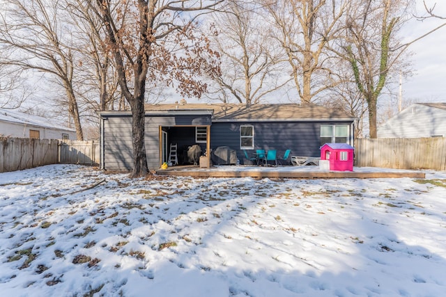 snow covered rear of property featuring a wooden deck