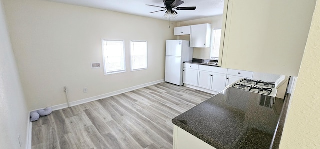 kitchen featuring white cabinets, light hardwood / wood-style flooring, white fridge, and ceiling fan