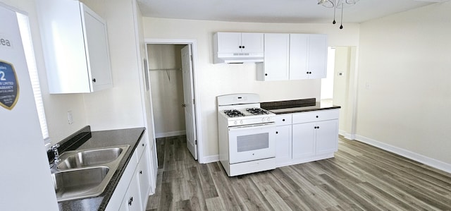 kitchen with white appliances, white cabinets, dark hardwood / wood-style floors, and sink