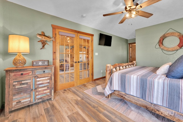 bedroom featuring ceiling fan, french doors, a textured ceiling, and hardwood / wood-style flooring