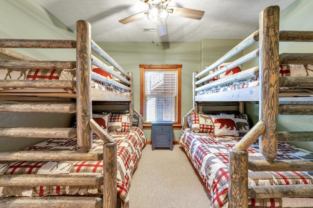 bedroom with ceiling fan, carpet, and a textured ceiling