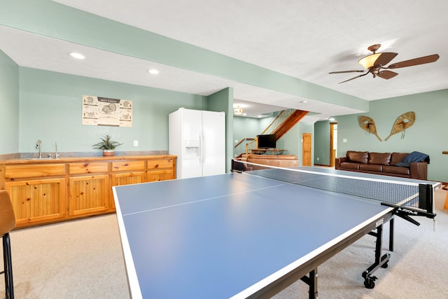 rec room with indoor wet bar, a textured ceiling, ceiling fan, and light colored carpet