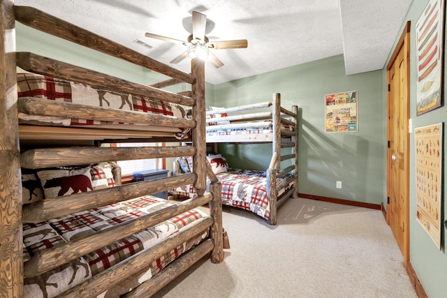 carpeted bedroom with ceiling fan and a textured ceiling