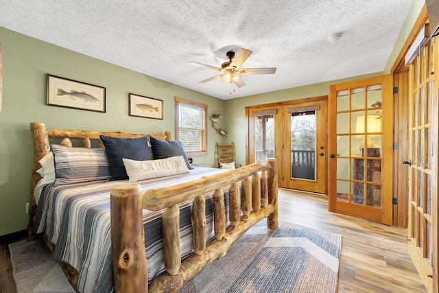 bedroom featuring a textured ceiling, french doors, light wood-type flooring, ceiling fan, and access to exterior