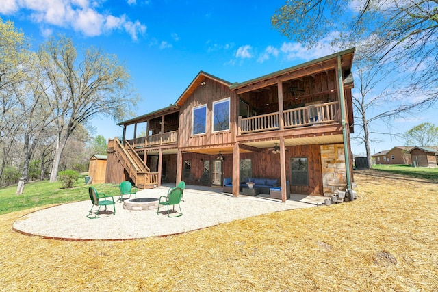 rear view of house with a yard, a patio area, an outdoor living space with a fire pit, and a wooden deck