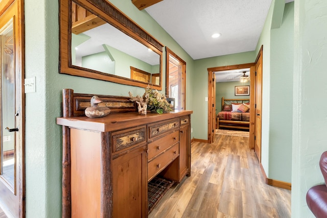 hallway featuring a textured ceiling and light wood-type flooring