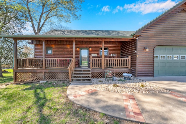 log cabin featuring covered porch and a garage