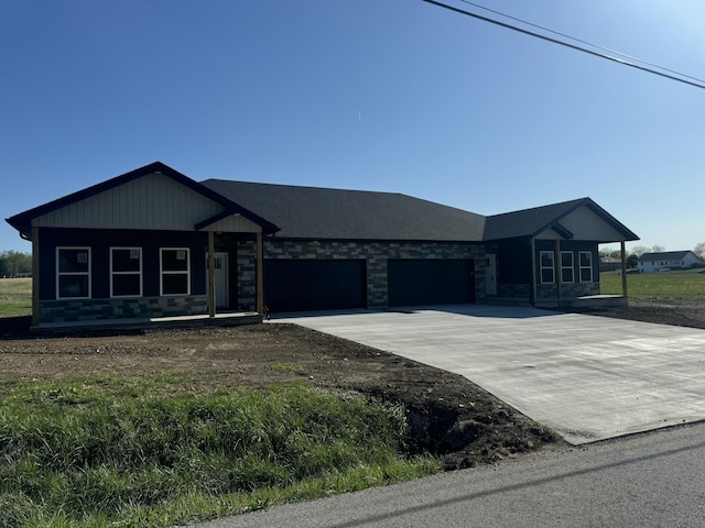 view of front of home featuring a garage, a porch, stone siding, and concrete driveway