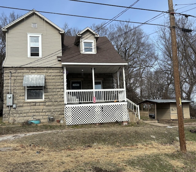 view of front facade with a carport, covered porch, and a storage unit