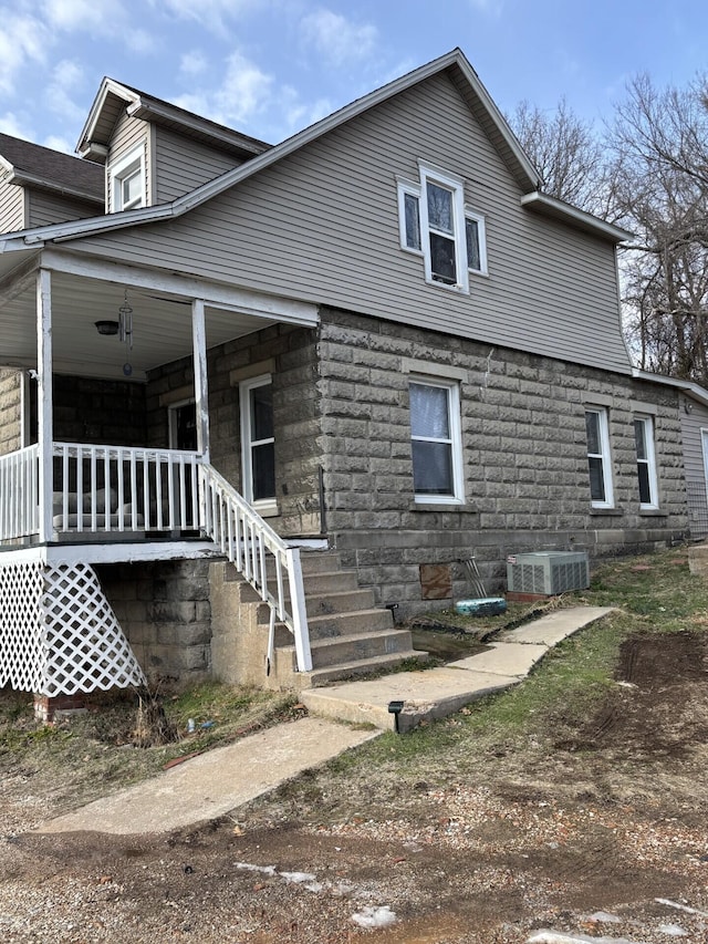 view of side of home featuring covered porch and central air condition unit