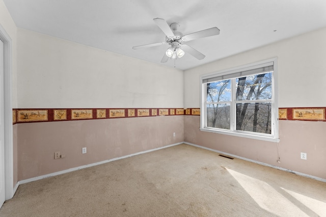 carpeted spare room featuring ceiling fan