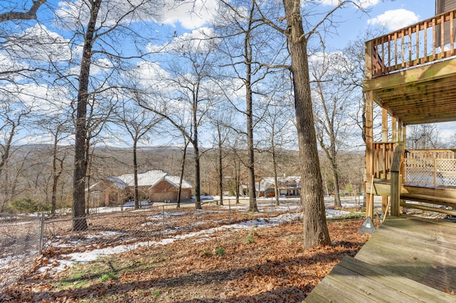 yard covered in snow featuring a deck with mountain view