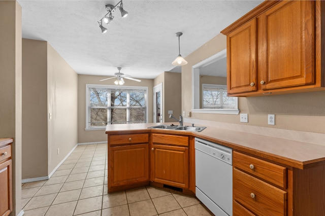 kitchen with dishwasher, light tile patterned floors, ceiling fan, pendant lighting, and sink