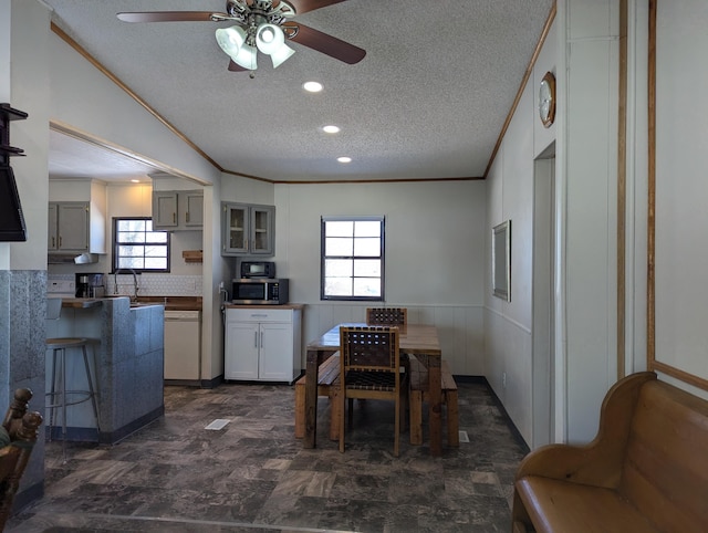 kitchen featuring a wealth of natural light, crown molding, and a textured ceiling