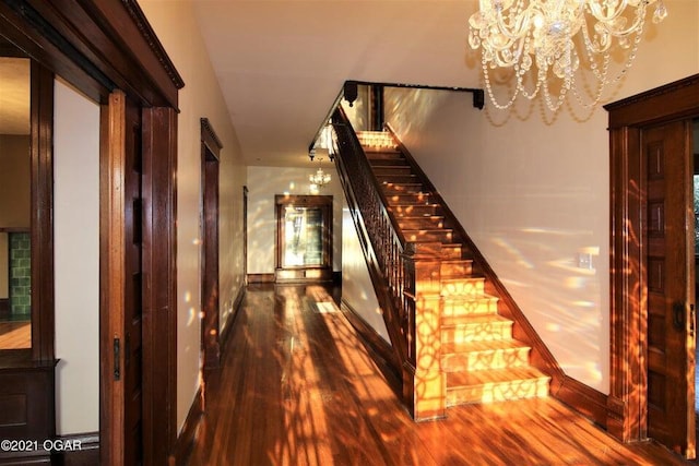 hallway featuring a notable chandelier and dark hardwood / wood-style flooring