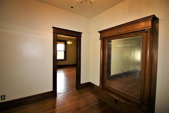 hallway with an inviting chandelier and dark hardwood / wood-style floors