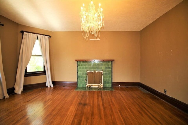 unfurnished living room featuring hardwood / wood-style floors, a chandelier, and a fireplace